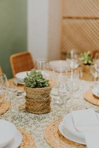 une table avec des assiettes et des verres et une plante sur elle dans l'établissement Natural Stay Apartamentos PassivHaus, à Logroño