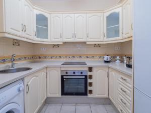 a kitchen with white cabinets and a sink and a dishwasher at Cubo's Dreams Alhaurin Room 4 in Alhaurín el Grande