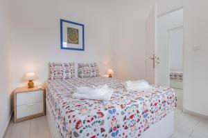a bedroom with a bed with two towels on it at Casa Santos Nicolau in Setúbal