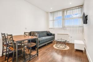 a living room with a couch and a table at Fantastic 1 Bed by Heathrow Airport in London