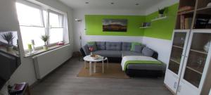 ein Wohnzimmer mit einer Couch und einem Tisch in der Unterkunft FeWo Hafner "Zuhause mit Ausblick" in Schnaittach