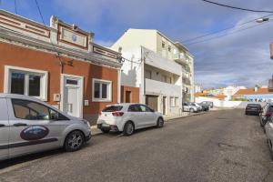 two cars parked on the side of a street at Casa Santos Nicolau in Setúbal