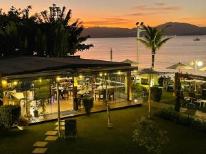 un ristorante con vista sull'acqua di notte di Hotel Sete Ilhas a Florianópolis