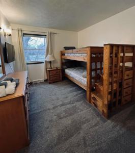 a bedroom with two bunk beds and a window at 5 Bedroom Lakeside Home Sleeps 12 - Shared Lake Access, Large Yard, Central Air, Fire Pit, Horseshoes & More! in Geneva
