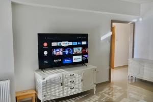 a flat screen tv on a white stand in a living room at Apartment Lola in Trebinje
