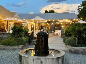 a fountain in front of a building with tables and umbrellas at The Duke of Bedford in Bedford