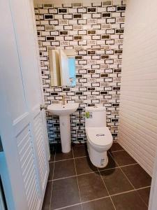 a bathroom with a toilet and a sink at Phakdee Place in Chanthaburi