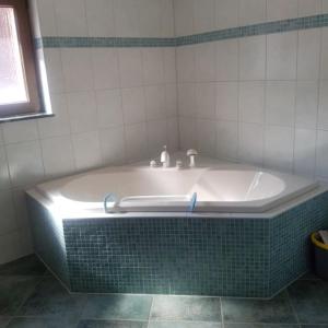 a bath tub in a bathroom with a tiled wall at Ferienwohnung in Ostseenähe in Kröpelin