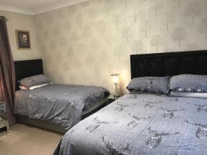 a bedroom with two beds with blue comforter at Campfield House in Fort William