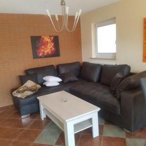 a living room with a brown couch and a coffee table at Ferienwohnung in Ostseenähe in Kröpelin