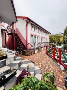 a house with a red railing and stairs next to a building at Lemberg Relax House in Lviv
