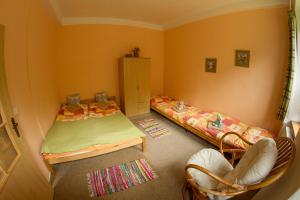 a small bedroom with two beds and a chair at Penzion Šumavous in Vimperk