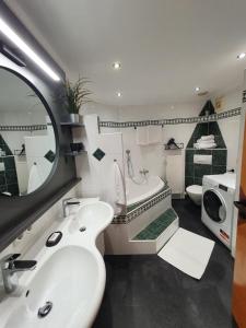La salle de bains est pourvue d'un lavabo, d'une baignoire et de toilettes. dans l'établissement Premium Mara, à Sankt Johann im Pongau