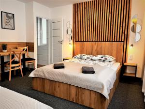1 dormitorio con 1 cama con cabecero de madera y mesa en Willa Dorota en Krynica Zdrój