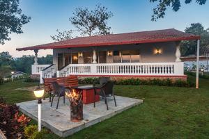 カルジャットにあるSaffronStays Mariposa by the River Montana, Karjatの庭のテーブルと椅子付きの家