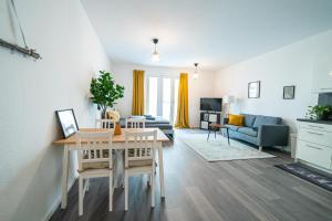 - un salon avec une table et une salle à manger dans l'établissement FULL HOUSE Premium Apartments Dresden A6, à Dresde