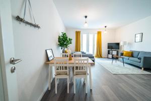 - un salon avec une table et un canapé dans l'établissement FULL HOUSE Premium Apartments Dresden A6, à Dresde