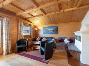 ein Zimmer in einem Blockhaus mit einem Sofa und Stühlen in der Unterkunft Ferienwohnung Scheffau in Scheffau am Wilden Kaiser