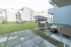un patio avec des chaises et une aire de jeux dans l'établissement FULL HOUSE Premium Apartments Dresden A6, à Dresde