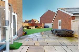 a backyard with a lawn and a house at Magnolia House in Leamington Spa