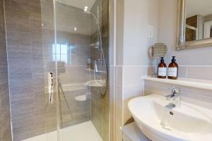 Un baño con ducha de cristal y lavabo. en Magnolia House, en Leamington Spa 16 fotos más