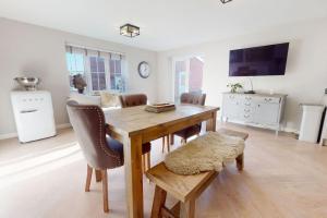 Un comedor con mesa y sillas de madera. en Magnolia House, en Leamington Spa