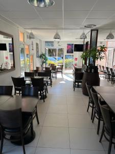 - une salle à manger avec des tables et des chaises dans l'établissement Hôtel des Arcades de Cachan - Grand Paris Sud, à Cachan