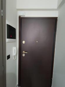 a brown door in a room with a phone at MODIANO CENTRAL STUDIO in Thessaloniki