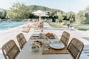 a table with food on it next to a pool at Apartments Villa Rania in Perdika