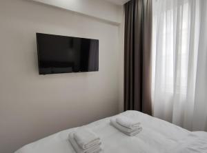 a room with a bed with a television and towels at MODIANO CENTRAL STUDIO in Thessaloniki