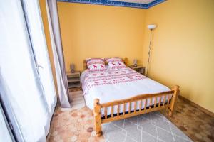 1 dormitorio con 1 cama en una habitación con paredes amarillas en Les Campanules, en Saint-Léger-les-Mélèzes