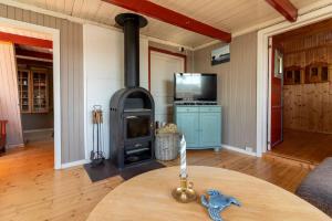 a living room with a wood stove in a room at Sharming cabin in Sund in Sund