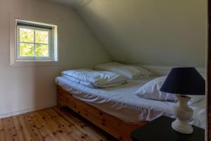 a bedroom with a bed with a lamp and a window at Sharming cabin in Sund in Sund