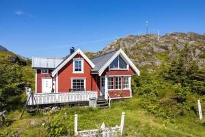 a red house on the side of a hill at Sharming cabin in Sund in Sund