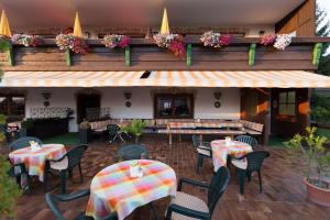 a patio with tables and chairs and a restaurant at Hotel Sonnleiten in Reit im Winkl