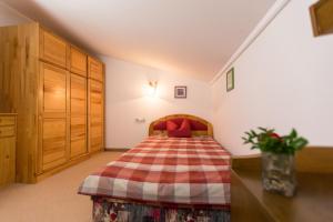 a bedroom with a bed with a checkered blanket at Hotel Sonnleiten in Reit im Winkl