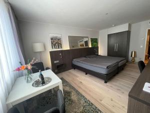 ein Schlafzimmer mit einem Bett und einem Tisch in einem Zimmer in der Unterkunft Gemütliches Apartment Nähe Medienhafen S-Bahn und free Parken in Düsseldorf