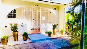 a building with a gate with potted plants on it at SugaLove Villa 30 Flamboyant Ave in Saint James