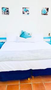 SugaLove Villa 30 Flamboyant Ave في سانت جيمس: سرير عليه أغطية بيضاء ومخدات زرقاء