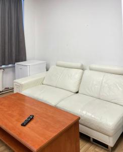 a living room with a white couch and a coffee table at Central Hostel Jelgava in Jelgava