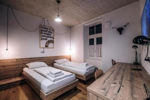 two beds in a room with a wooden floor at Becycle Sustainable stay and travel in Maribor
