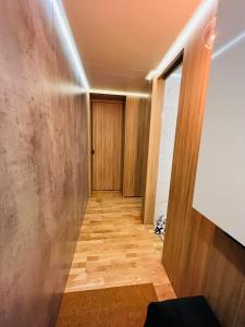 pasillo con suelo de madera y puerta en Apartament Centrum Wyzwolenia, en Szczecin