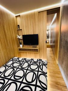 sala de estar con TV y alfombra blanca y negra en Apartament Centrum Wyzwolenia, en Szczecin