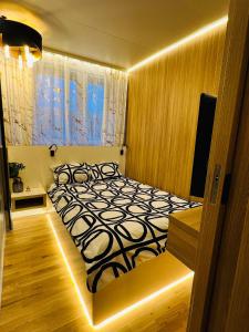 1 dormitorio con 1 cama con edredón blanco y negro en Apartament Centrum Wyzwolenia, en Szczecin