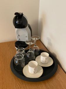a tray with cups and cups on a table with a coffee maker at Sunny Aisa Apartment in Pärnu