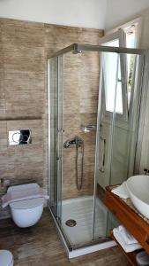 a bathroom with a shower and a sink at Sarakiniko Rooms in Adamantas