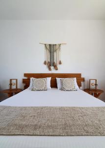a bedroom with a large white bed with two pillows at Sarakiniko Rooms in Adamantas