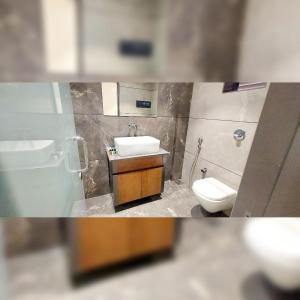 La salle de bains est pourvue d'un lavabo et de toilettes. dans l'établissement Hotel Red Chillee Restro, à Silvassa