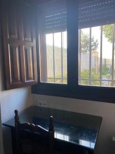 a kitchen with two windows and a table in a room at Apartamentos de Astroturismo la Cañada in Torrejón el Rubio