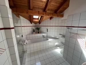 a bathroom with a tub and a toilet at the Jad B&B in Cormoret